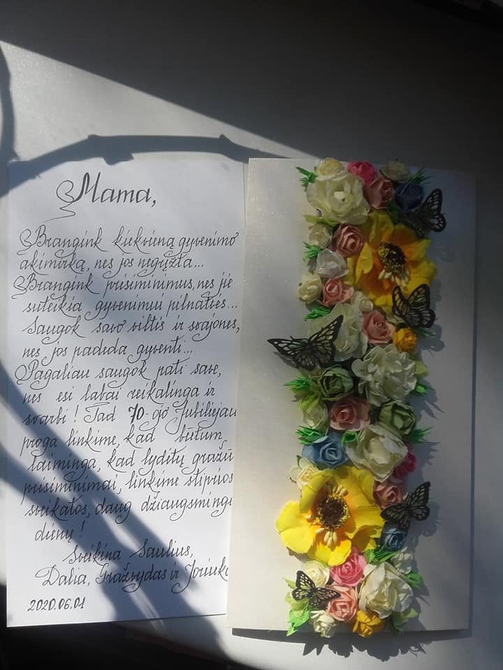 Baltas atvirukas su gėlėmis šalia laiško Mamai